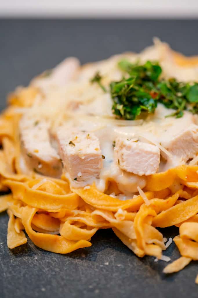 Close up of garlic alfredo pasta with chunks of chicken