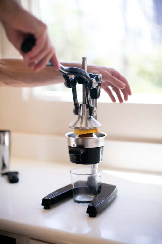 An orange in a fruit juicer