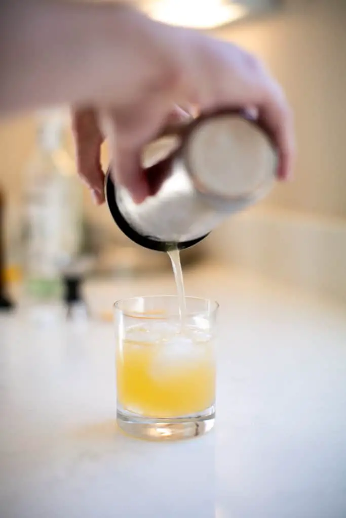 Pouring a cocktail from a shaker to the glass