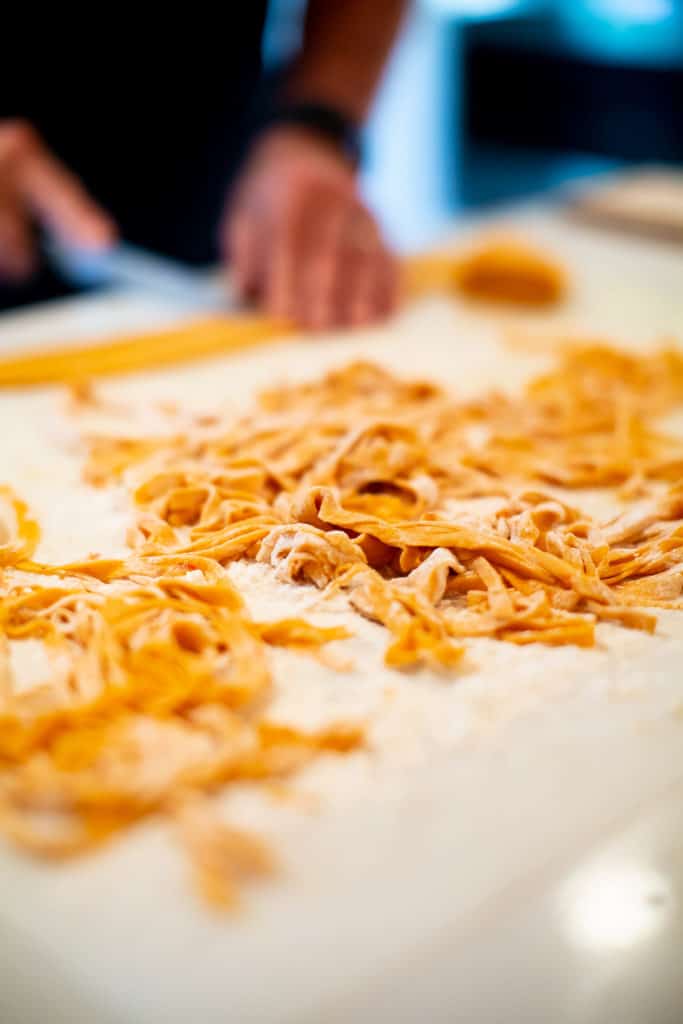 Red pepper pasta dough covered in flour