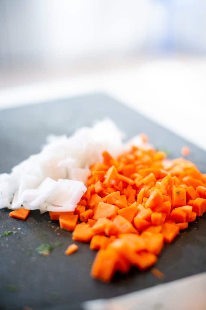 Diced carrots and chopped onions ready for sautéing