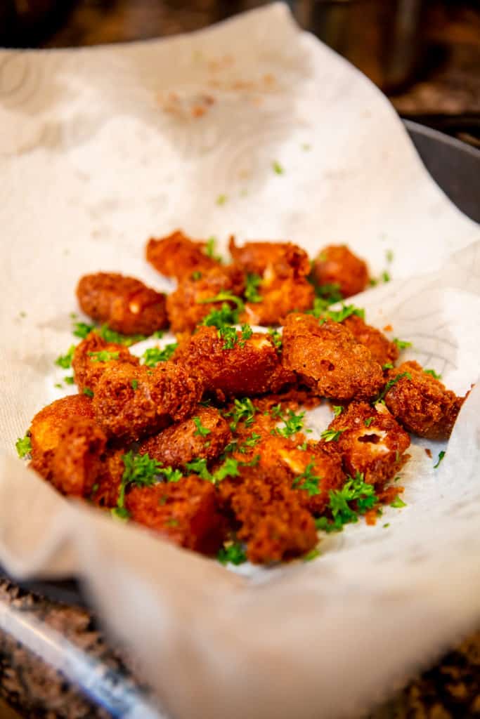 Deep fried cheese curds on a paper towel lined plate