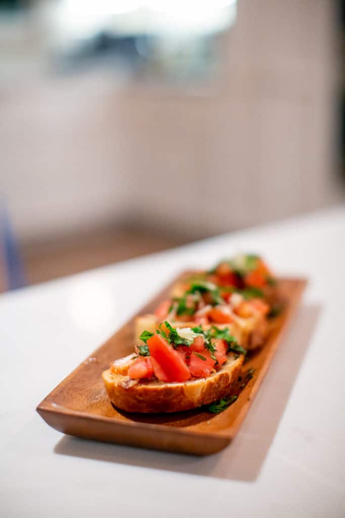 Close photo of bruschetta served on a wooden plate