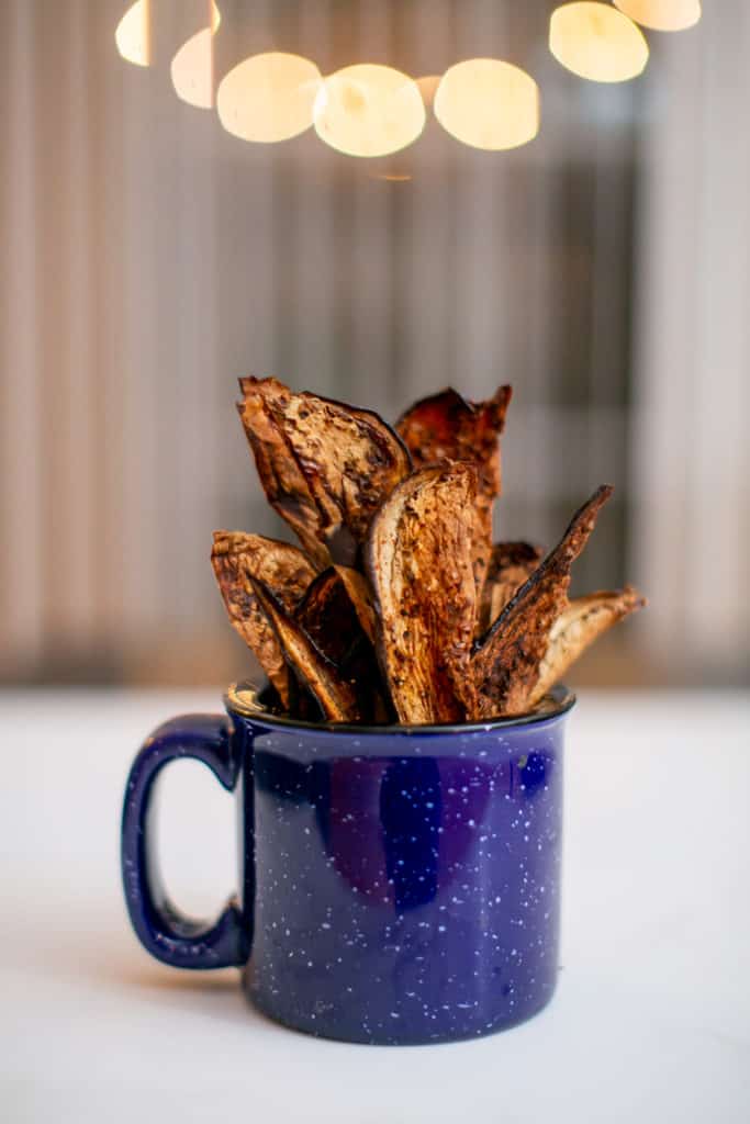 Close photo of eggplant chips in a blue mug