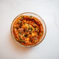 French cheese souffle with herbs served in a clear bowl placed on a marbled table