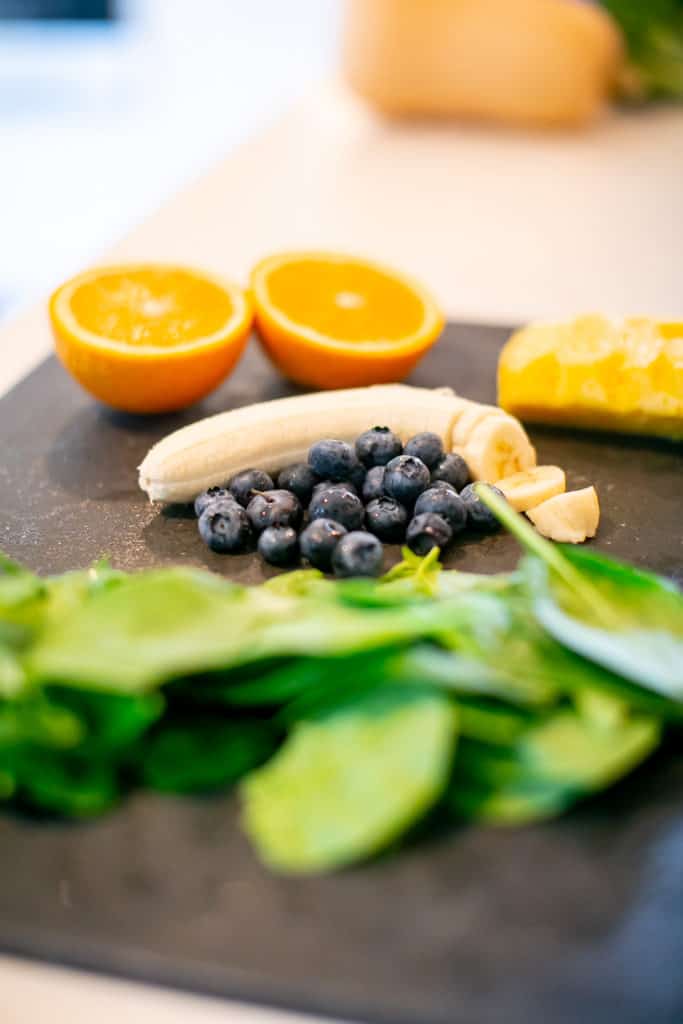 Green smoothie ingredients prepped on a cutting board