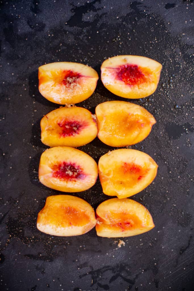 Sliced peaches on a black tray