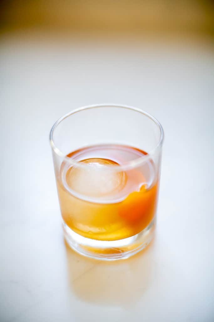 Maple bourbon smash cocktail served cold with an ice ball