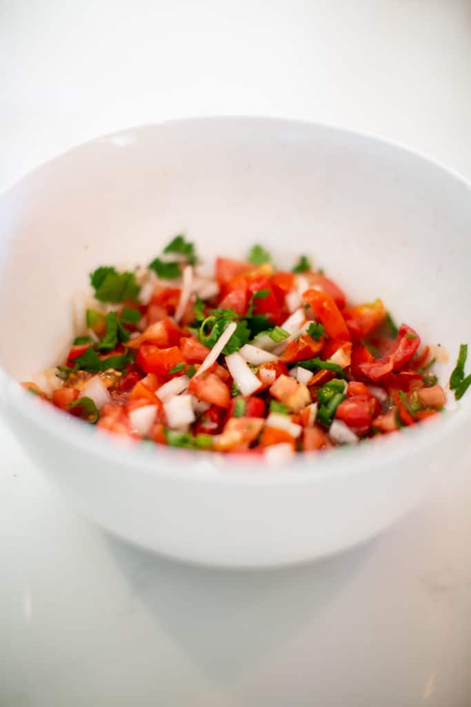Close photo of pico de gallo served in a white bowl