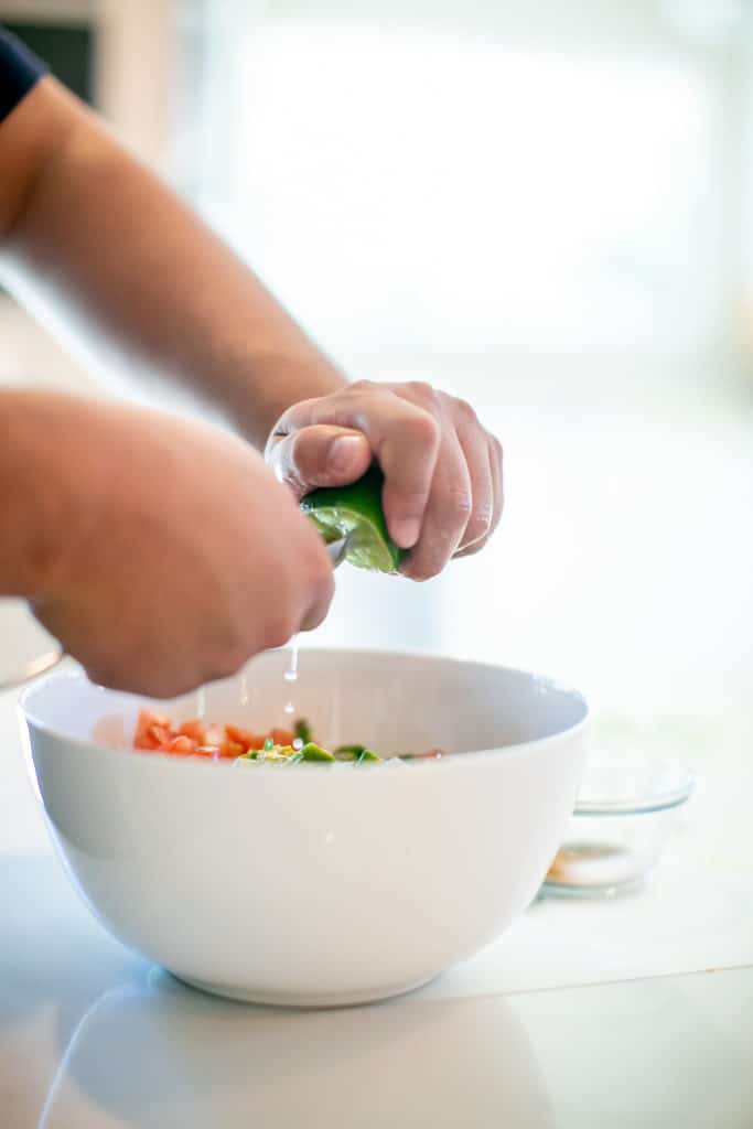 Squeezing a lime to keep guacamole from turning brown