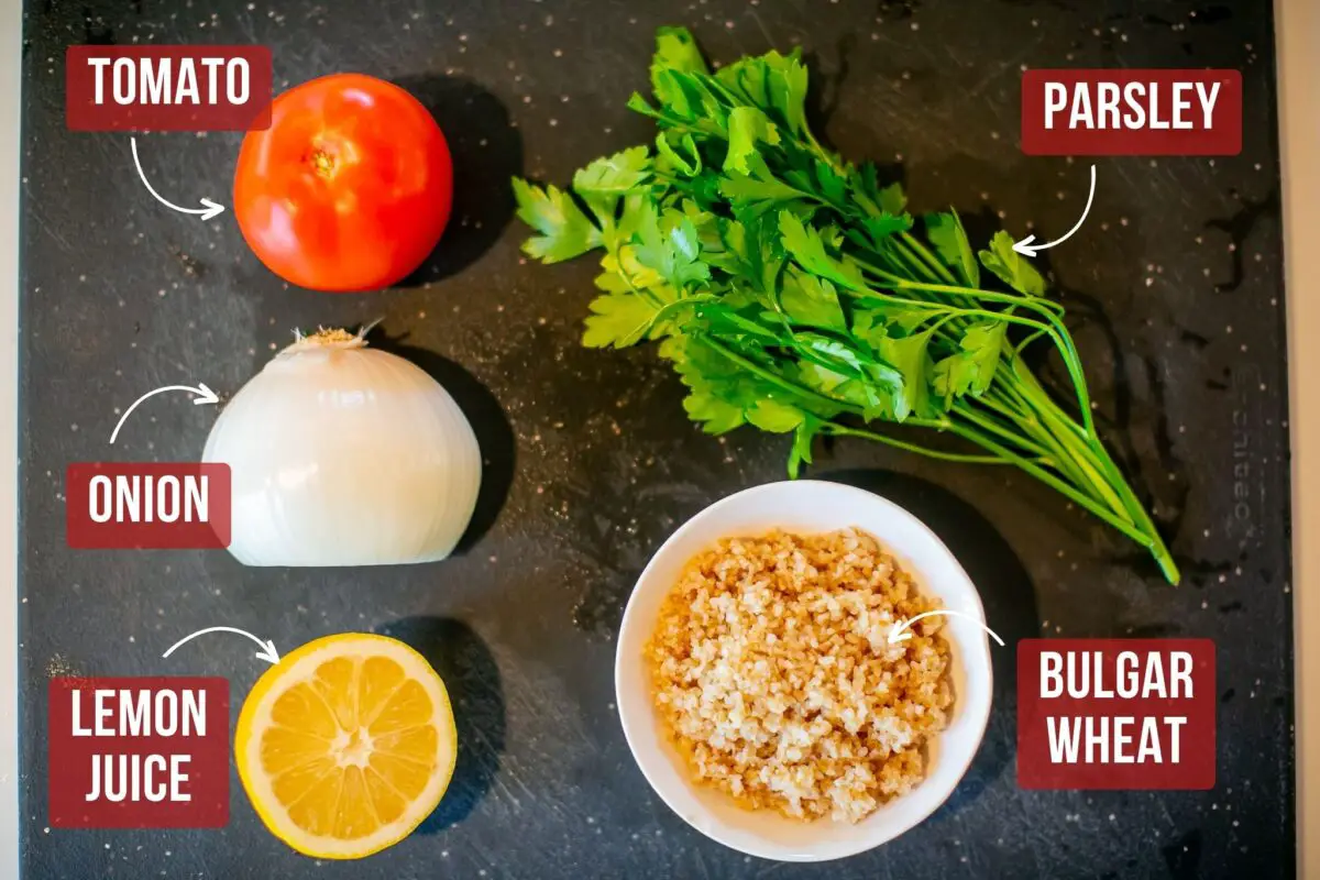 Ingredients for Middle Eastern Tabouli Salad on a black cutting board in the kitchen