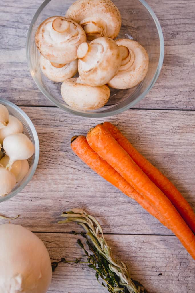 Ingredients for Beef Bourguignon including carrots, mushrooms, and onions