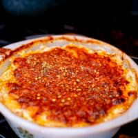 Baked potatoes au gratin in a white casserole placed on a black stove