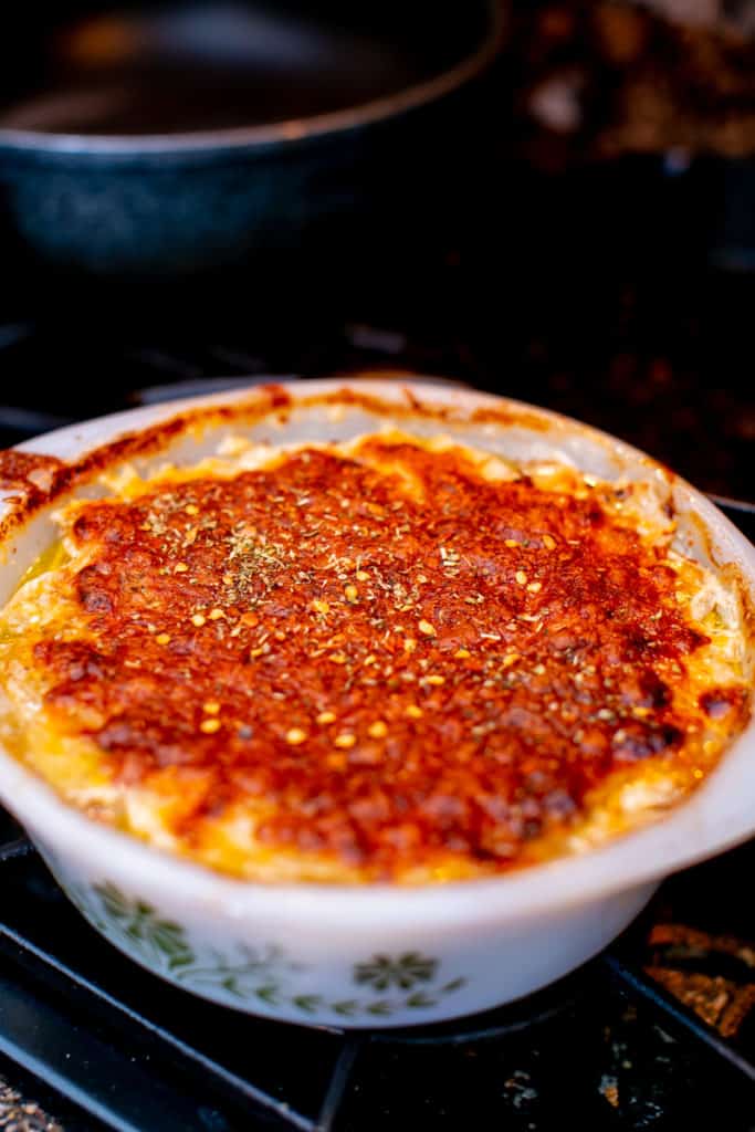 Baked potatoes au gratin in a white casserole placed on a black stove