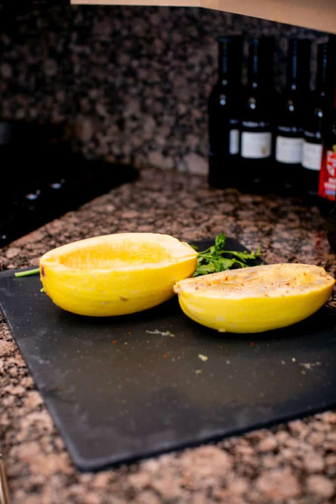 A squash cut in half on a chopping board