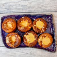 Top view of Yorkshire popovers on a purple plate put on a wooden surface