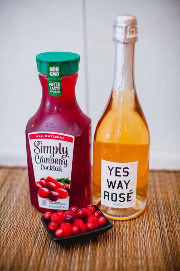 Cranberry cocktail, sparkling wine and a bowl of fresh berries