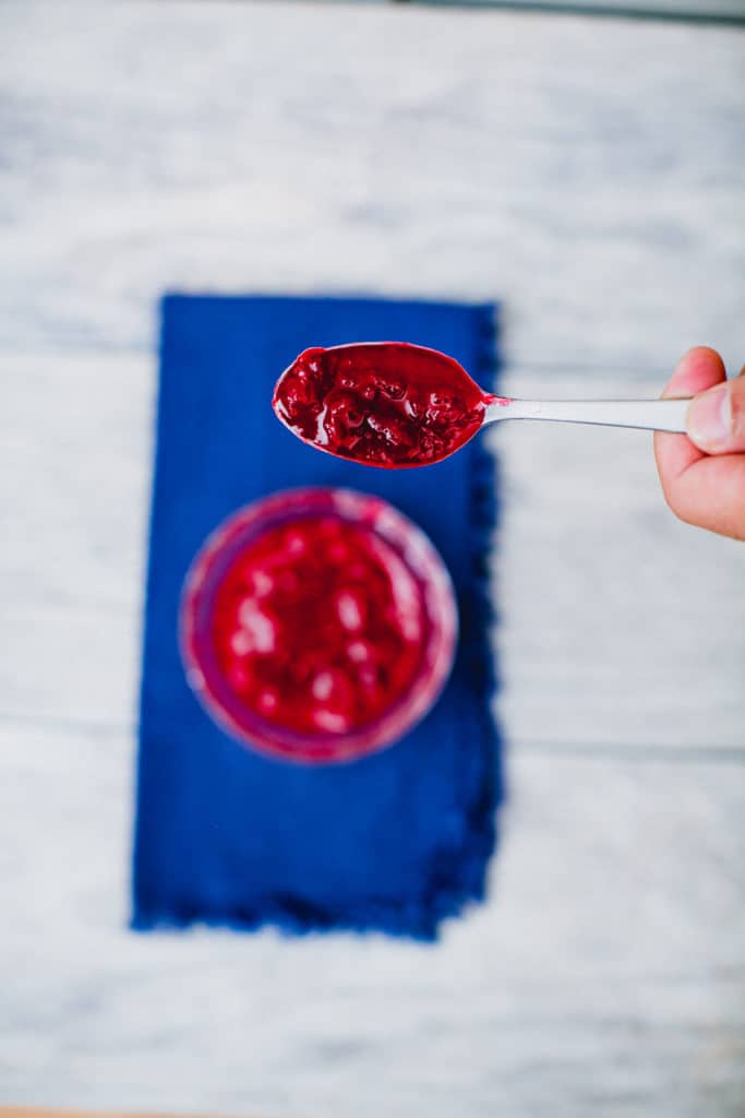 Person holding a spoonful of cranberry sauce
