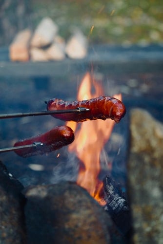 Bratwursts being cooked on an open fire