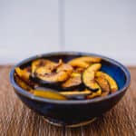Baked cinnamon spice acorn squash served on a blue bowl placed on a brown placemat