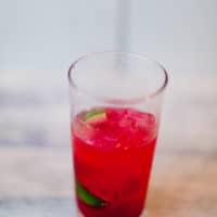 An ice-cold cranberry daiquiri served in a glass put on a wooden surface