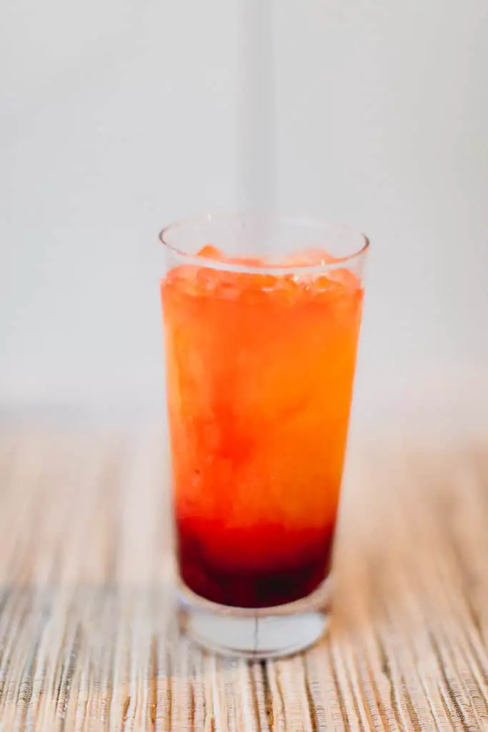 A finished layered drink of a tequila sunrise cocktail