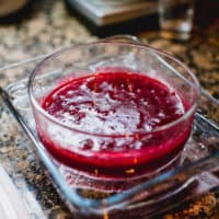 Homemade cranberry sauce in a clear bowl placed on a serving tray