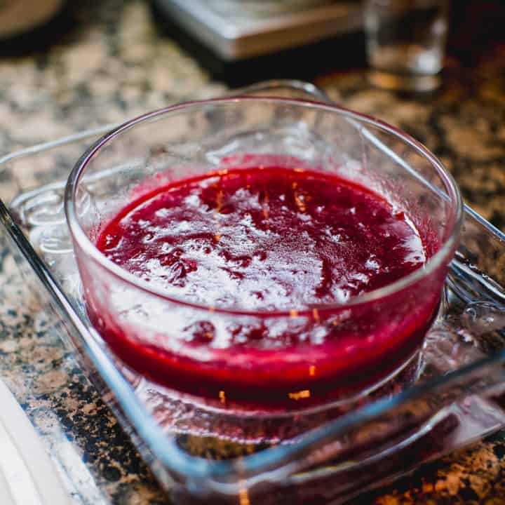Homemade cranberry sauce in a clear bowl placed on a serving tray