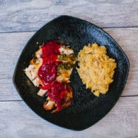 Oven-roasted brined turkey breast served on a black plate placed on a wooden surface