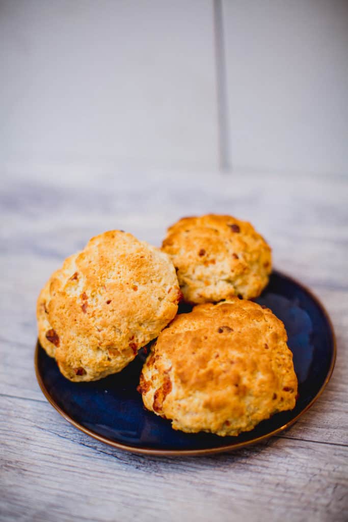 Three pieces of cheesy biscuits stacked on a plate