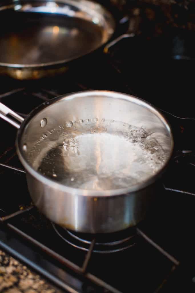 Water being boiled in a pot for blanching green beans