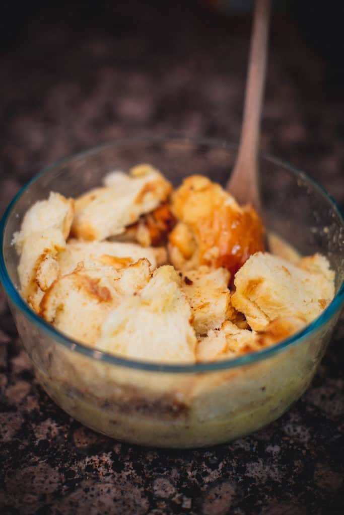 Ingredients for eggnog bread pudding being mixed in a bowl