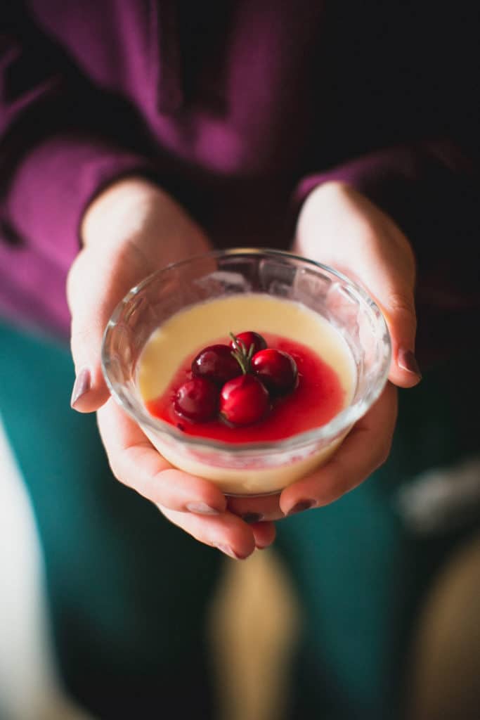Person holding a cup of eggnog panna cotta 
