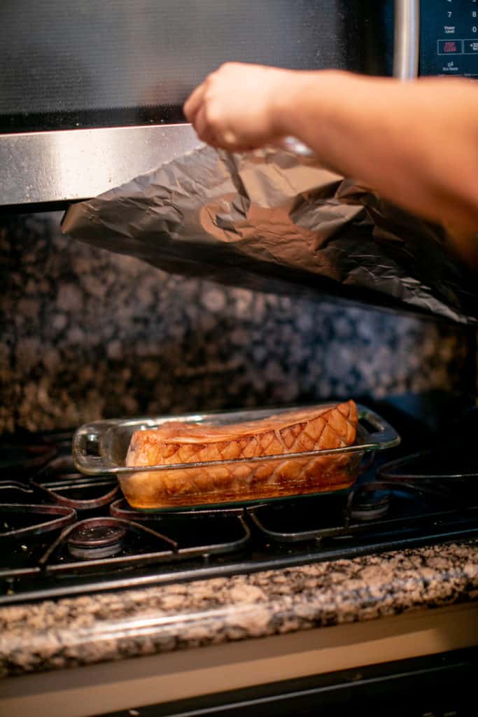 Kalua pork being wrapped in foil before going in an oven