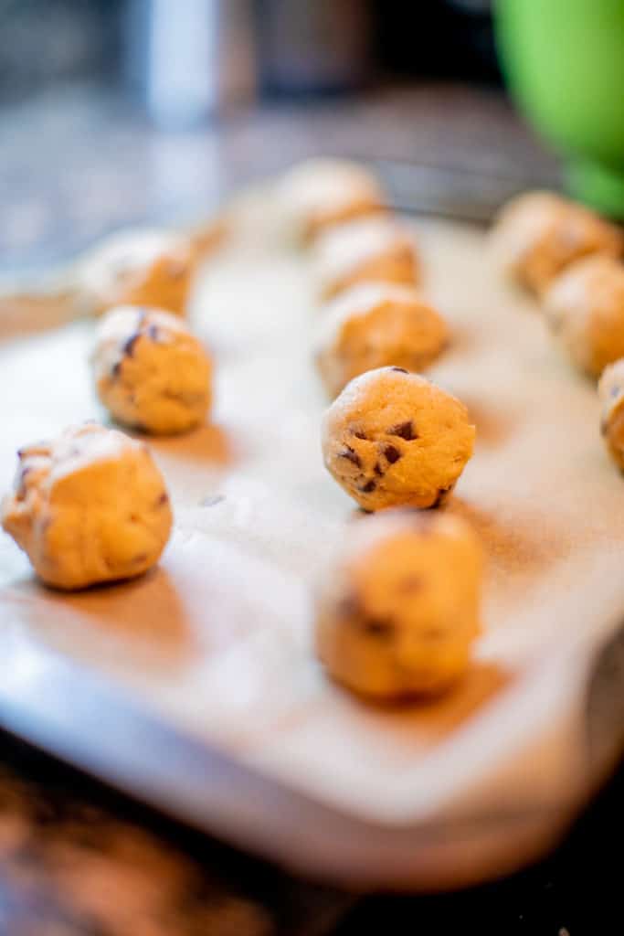 Cookie dough rolled into a ball and placed on a lined baking sheet