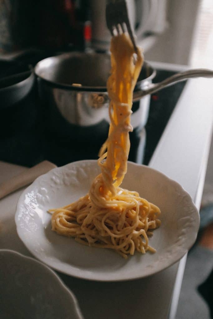 Person putting one serving of pasta on a bowl