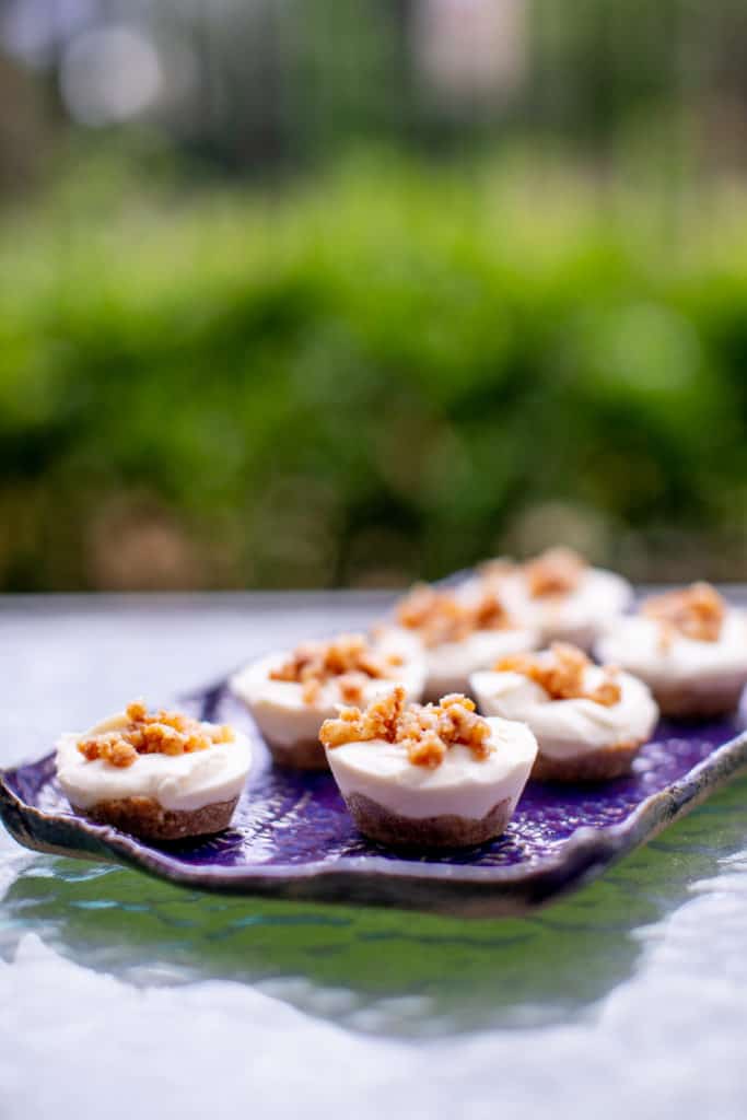 A no bake cheesecake bites are served on a purple tray placed on a glass table