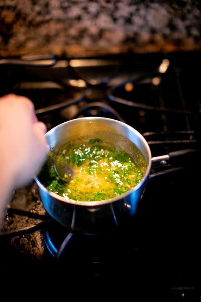 Mixing butter, parsley, garlic and lemon in a saucepan