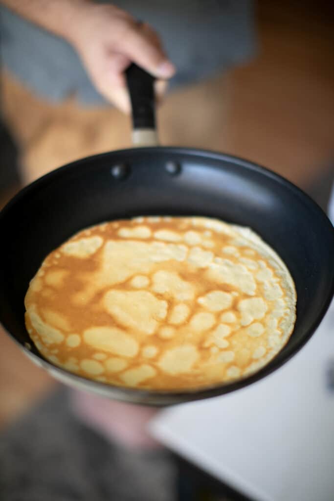 French crepe being cooked in a cast iron pan