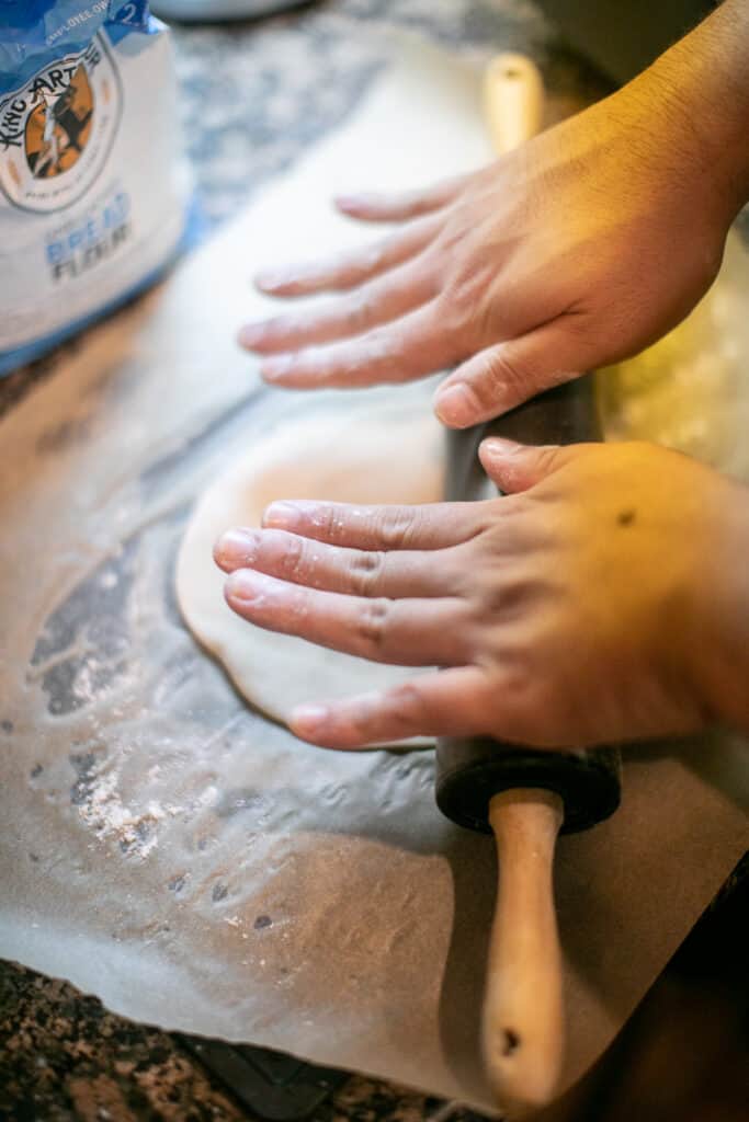 Close up of a person rolling dough