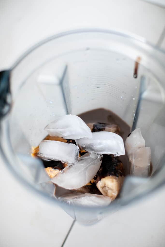 Mixing all the ingredients for a peanut butter banana smoothie recipe in a blender