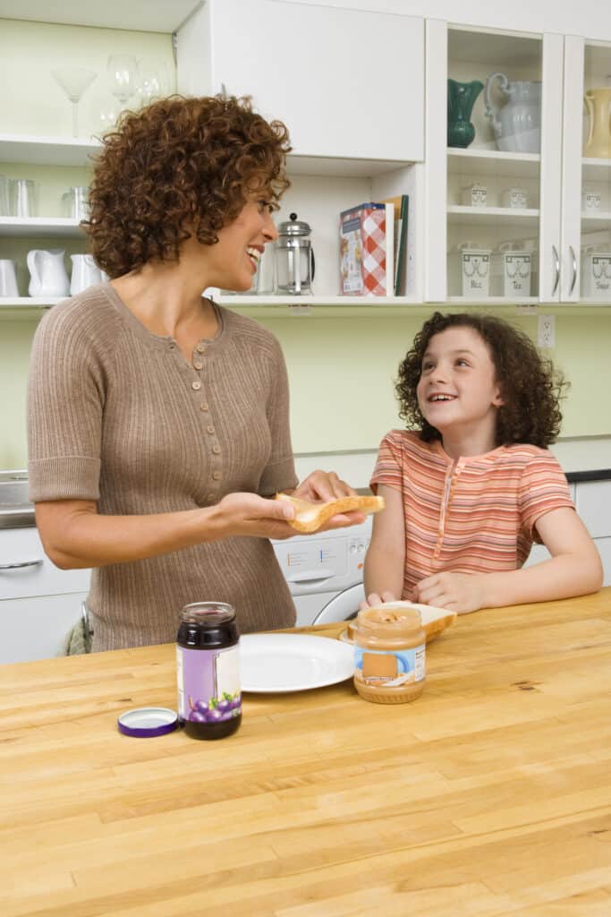 Mom and daughter making a peanut butter and jelly sandwich