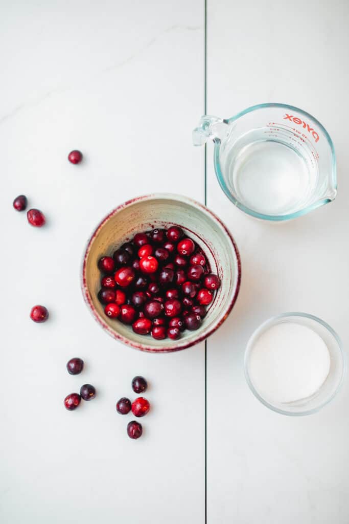 Cranberries with sugar and water on a table