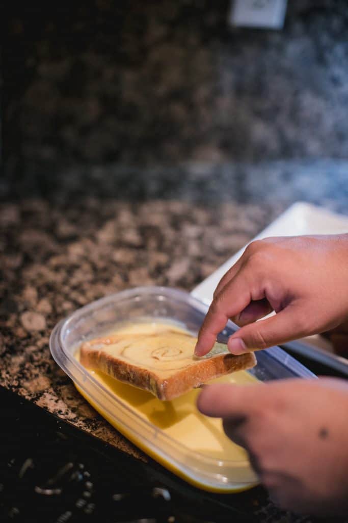 Bread being dipped in an egg mixture