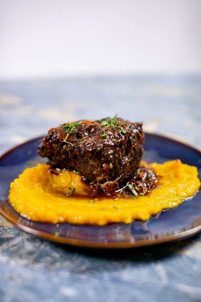 Prepared butternut squash puree recipe with braised meat on a plate