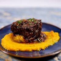 Prepared butternut squash puree recipe with braised meat on a plate