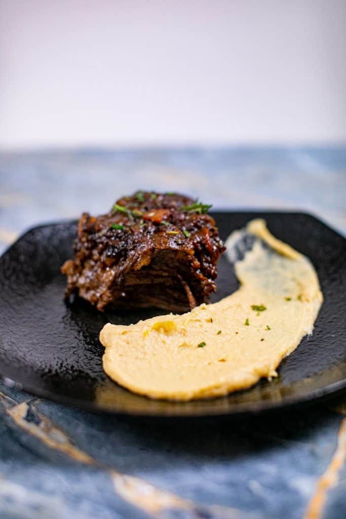 Prepared garlic mashed parsnips recipe with entrée on a plate