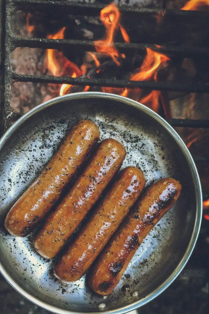 Sausages on a metal pan with fire