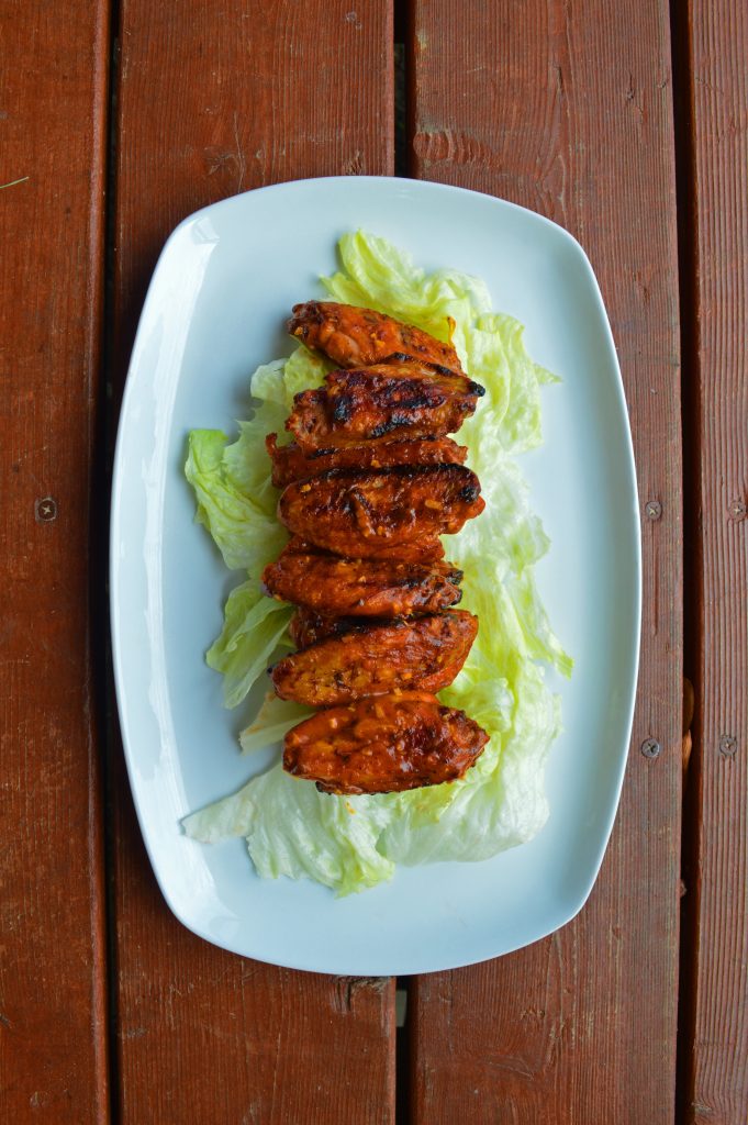 Chicken wings line up vertically on a plate