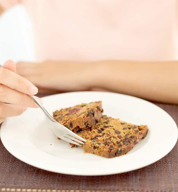 Woman eating a piece of fruitcake